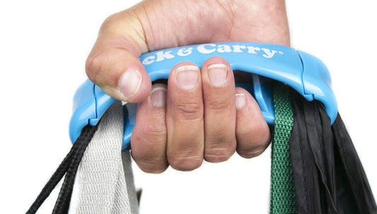 Hand using a blue Click & Carry grocery bag carrier to hold many shopping bags at once