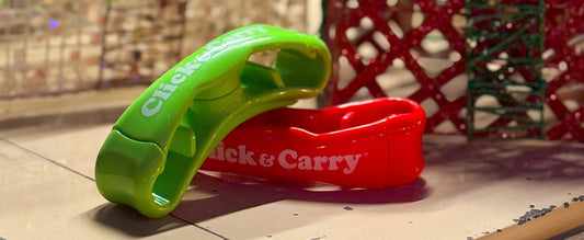 Red and green grocery bag carrying handles leaning on each other in front of Christmas gifts