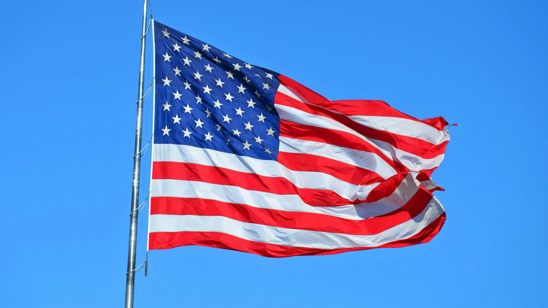 American flag waving in the wind in front of a clear blue sky