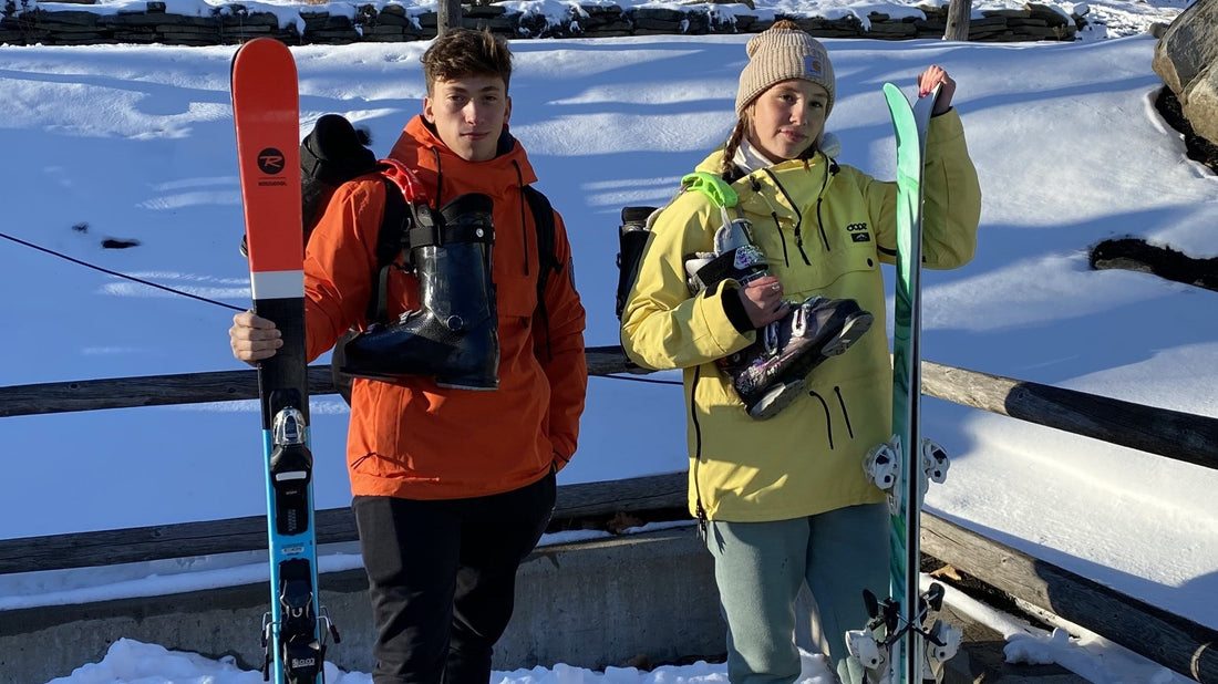 Two teenagers on a snowy using their Click & Carry handles to tote their ski boots hands-free