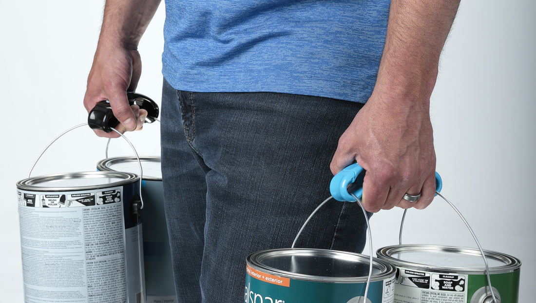Dad lugging multiple paint cans using two Click & Carry handles, one black and one blue